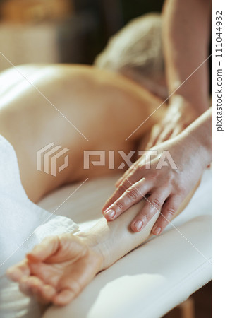 Closeup on massage therapist in spa salon massaging clients arm Closeup on massage therapist in spa salon massaging clients arm 111044932