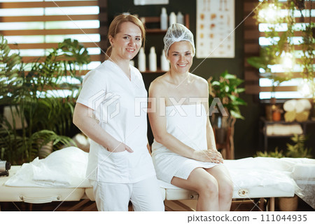 medical massage therapist in spa salon with happy client 111044935