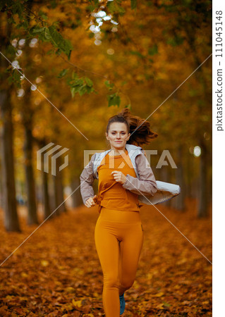 elegant female in fitness clothes in park jogging 111045148