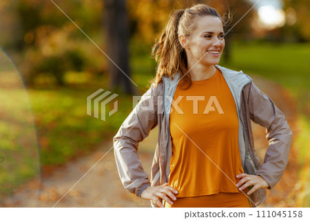 happy stylish woman in fitness clothes in park relaxing happy stylish woman in fitness clothes in park relaxing 111045158