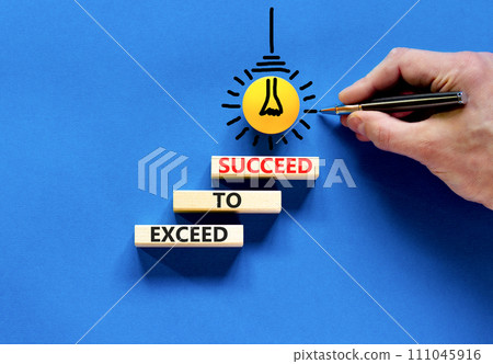 Exceed to succeed symbol. Concept words Exceed to succeed on beautiful wooden blocks. Beautiful blue table blue background. Businessman hand. Business and exceed to succeed concept. Copy space. 111045916