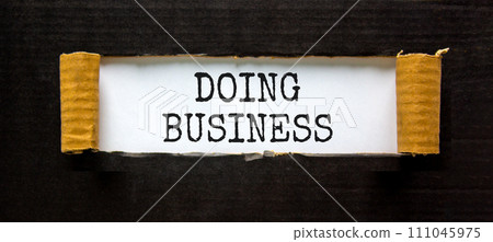 Doing business symbol. Concept words Doing business on beautiful white paper. Beautiful black table black background. Business, motivational Doing business concept. Copy space. Doing business symbol. Concept words Doing business on beautiful white paper. Beautiful black table black background. Business, motivational Doing business concept. Copy space. 111045975