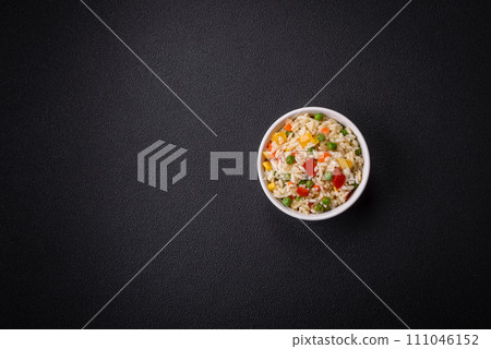 Delicious white boiled rice with vegetables, sweet peppers, carrots, peas, salt and spices 111046152