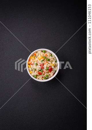 Delicious white boiled rice with vegetables, sweet peppers, carrots, peas, salt and spices 111046153