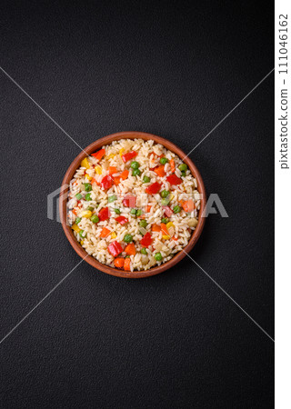 Delicious white boiled rice with vegetables, sweet peppers, carrots, peas, salt and spices 111046162