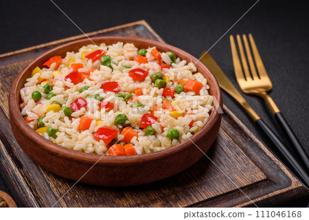 Delicious white boiled rice with vegetables, sweet peppers, carrots, peas, salt and spices 111046168