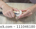 The process of peeling mushrooms. A woman's hands peel mushrooms with a knife, close-up. Cooking mushrooms. 111046180