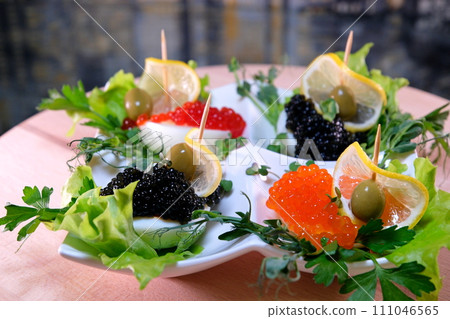 Luxurious appetizer of quail eggs with paste of squid, shrimp and black caviar on potato and cheese chips. High quality Luxurious appetizer of quail eggs with paste of squid, shrimp and black caviar on potato and cheese chips. High quality 111046565