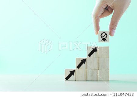 Hand-putting a symbol of quality assurance and arrow increasing on wooden cube for quality enhancement of guarantee product and ISO service concept. Enhance the value of business. Proposal compliance, Hand-putting a symbol of quality assurance and arrow increasing on wooden cube for quality enhancement of guarantee product and ISO service concept. Enhance the value of business. Proposal compliance, 111047438