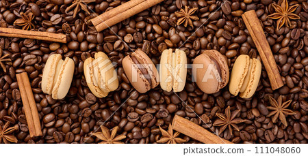 Multi-colored macarons on a background of coffee beans Multi-colored macarons on a background of coffee beans 111048060