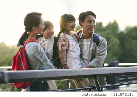 asian family with two children looking at view in city park asian family with two children looking at view in city park 111048115