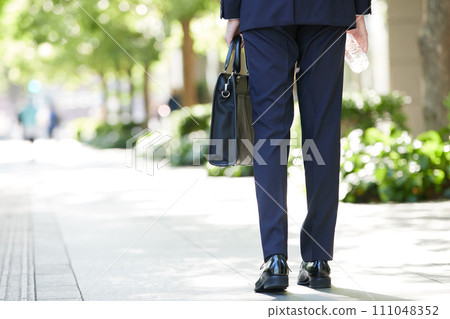 Business image of a man walking with a business bag Business image of a man walking with a business bag 111048352