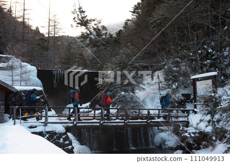 Winter scene of climbers crossing the bridge on the Shibu-no-Yu route of Mt. Higashitengu in midwinter in Chino City, Nagano Prefecture Winter scene of climbers crossing the bridge on the Shibu-no-Yu route of Mt. Higashitengu in midwinter in Chino City, Nagano Prefecture 111049913