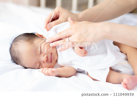 新生兒微笑是因為清潔耳朵的感覺真好。新生兒微笑。 111049939