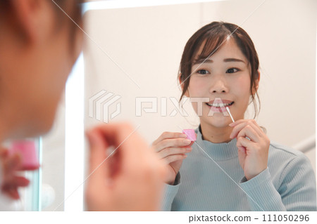 一位女士在嘴唇上塗抹凡士林 一位女士在嘴唇上塗抹凡士林 111050296