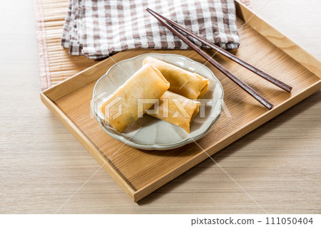 Fried Spring rolls on plate with chopsticks and spoon - Asian food style Fried Spring rolls on plate with chopsticks and spoon - Asian food style 111050404