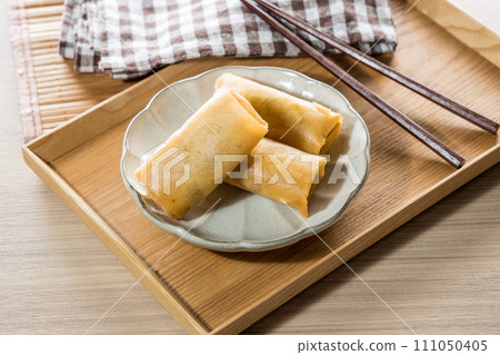 Fried Spring rolls on plate with chopsticks and spoon - Asian food style Fried Spring rolls on plate with chopsticks and spoon - Asian food style 111050405