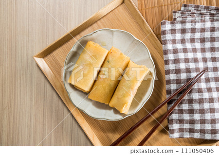 Fried Spring rolls on plate with chopsticks and spoon - Asian food style Fried Spring rolls on plate with chopsticks and spoon - Asian food style 111050406