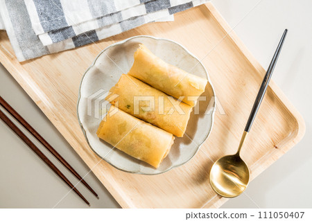 Fried Spring rolls on plate with chopsticks and spoon - Asian food style Fried Spring rolls on plate with chopsticks and spoon - Asian food style 111050407
