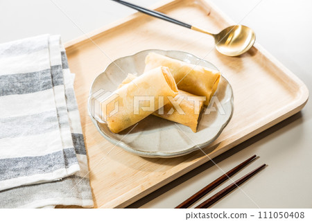 Fried Spring rolls on plate with chopsticks and spoon - Asian food style Fried Spring rolls on plate with chopsticks and spoon - Asian food style 111050408