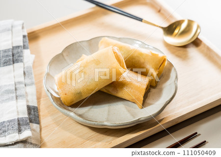 Fried Spring rolls on plate with chopsticks and spoon - Asian food style Fried Spring rolls on plate with chopsticks and spoon - Asian food style 111050409