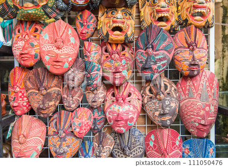 Group of traditional Bali Batik mask hanging for souvenir sell in Ubud market, Bali island of Indonesia. Group of traditional Bali Batik mask hanging for souvenir sell in Ubud market, Bali island of Indonesia. 111050476