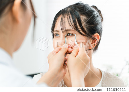 A female patient and a cosmetic surgeon simulating double plastic surgery at a beauty clinic A female patient and a cosmetic surgeon simulating double plastic surgery at a beauty clinic 111050611