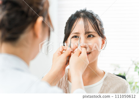 A female patient and a cosmetic surgeon simulating double plastic surgery at a beauty clinic A female patient and a cosmetic surgeon simulating double plastic surgery at a beauty clinic 111050612