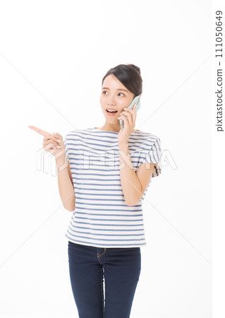 A woman in a T-shirt talking on a mobile phone 111050649