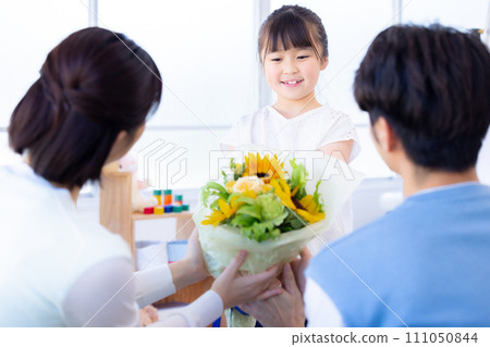 Family portrait: Girl giving a bouquet of flowers on anniversary 111050844