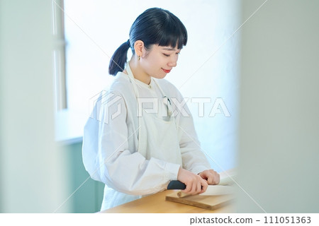 年輕女子用刀切配料 111051363