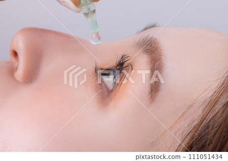 Woman applying eye drops Woman applying eye drops 111051434