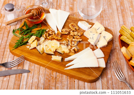 Various types of cheese on wooden board 111051633