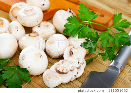 Raw champignons on wooden table Raw champignons on wooden table 111051692