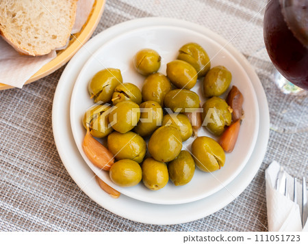 Light snack - few of pickled green pitted olives and slice of bran bread 111051723