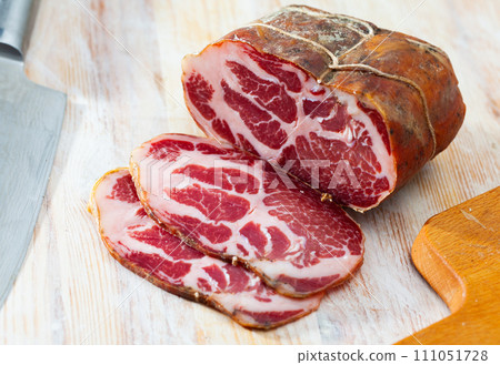 Sliced lacon curado on wooden background 111051728