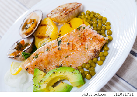 Tasty fried trout fillets, served with seashells, vegetables and avocado 111051731