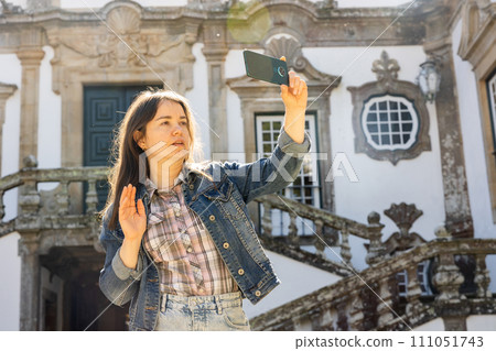 Female tourist having video call while standing at Mateus Palace 111051743