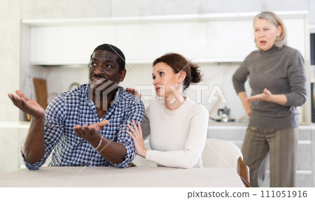 Wife calms husband down during quarrel with mother-in-law Wife calms husband down during quarrel with mother-in-law 111051916