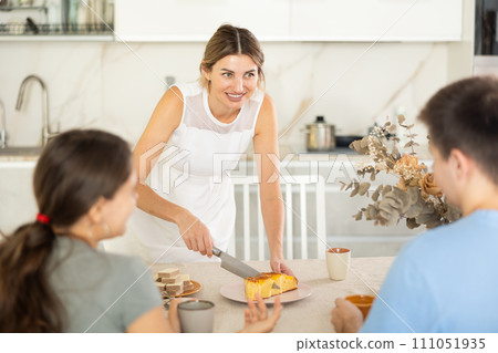 Happy woman offers young couple to try delicious homemade pie 111051935