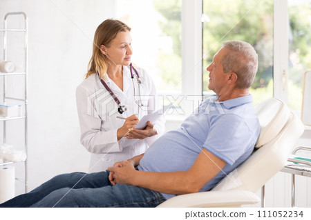 Adult woman doctor making notes in medical office 111052234