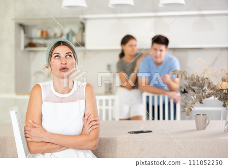 Thoughtful woman who had conflict with adult children while cooking dinner in kitchen 111052250