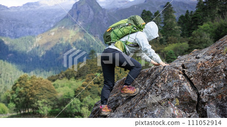 Woman hiker climbing to mountain top in tibet 111052914