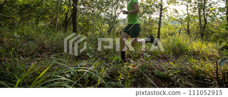 Woman trail runner running at tropical forest mountain peak 111052915