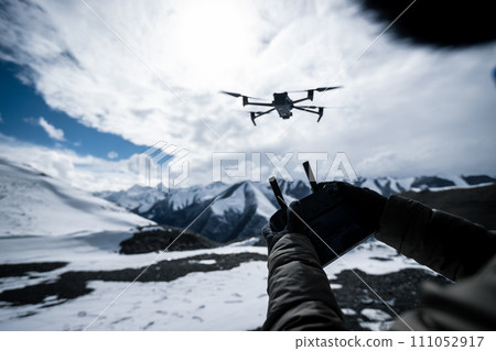Flying drone in high altitude mountains 111052917