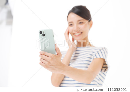 拿著智慧型手機的 30 多歲微笑的女人 111052991