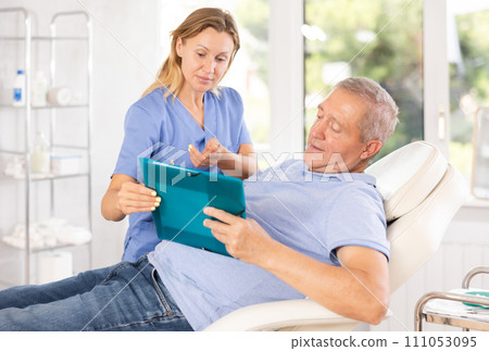 Adult woman doctor giving contract to patient for signing 111053095