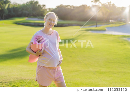 Energetic pregnant woman takes her workout outdoors, using an exercise mat for a refreshing and health-conscious outdoor exercise session Energetic pregnant woman takes her workout outdoors, using an exercise mat for a refreshing and health-conscious outdoor exercise session 111053130