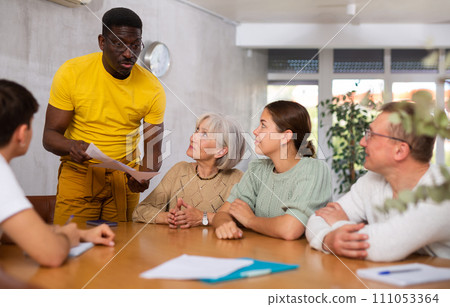 Group of multinational people discussing documents at table 111053364