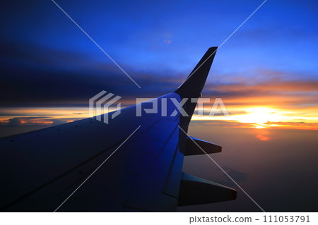 新加坡上空的日落和太平洋上空飛機的主翼 新加坡上空的日落和太平洋上空飛機的主翼 111053791